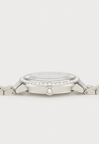 Silver watch with a round case, crystal accents around the bezel, and a metal link strap. Smooth texture and removable links.