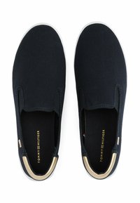 Scarpe slip-on in tela blu navy con suola in gomma bianca e dettaglio dorato sul tallone. Presentano pannelli elastici ai lati e soletta con marchio.