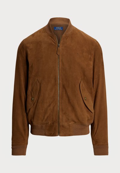 Casaco bomber de camurça castanha com fecho éclair na frente, punhos canelados, dois bolsos laterais e um pequeno logotipo no peito. Textura suave.
