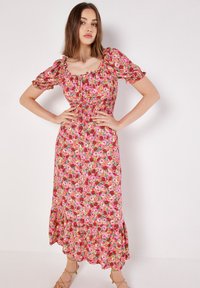Blumiges Maxikleid mit Puffärmeln. Hat einen rosa Hintergrund und farbenfrohe Blumenmuster. Elastischer Taillenbund und Rüschensaum.