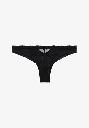 Black lace thong with sheer mesh panels, scalloped edges, and a front cutout detail. Features delicate floral patterns throughout.