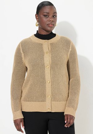 Cardigan en maille beige avec un design en maille ouverte, un col rond, des poignets côtelés et des boutons sur le devant. Tissu texturé, coupe décontractée.