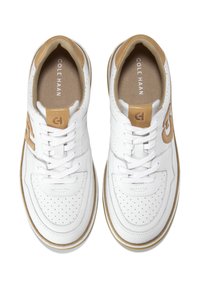 Par de zapatillas de cuero blanco Cole Haan con puntera perforada, acentos en color marrón, cordones blancos y plantillas con marca, vistas desde arriba.
