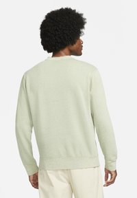 Ljusgrön sweatshirt med texturerad tyg, långa ärmar och ribbade muddar. Har en rund halsringning och en avslappnad passform utan synliga mönster.