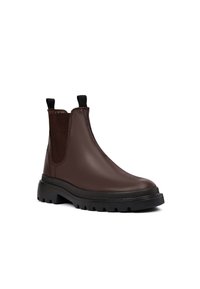 Bruine leren chelsea boots met een getextureerd elastieken paneel, zwarte rubberen zool en handvatten voor eenvoudig aan- en uittrekken. Strak, modern ontwerp.