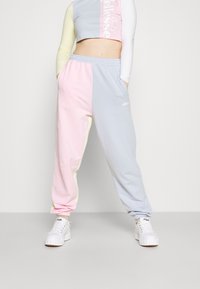 Lehké tepláky s barevnými bloky v růžové, modré a žluté barvě s pasem na stažení a manžetami u kotníků. Detaily loga vpředu.