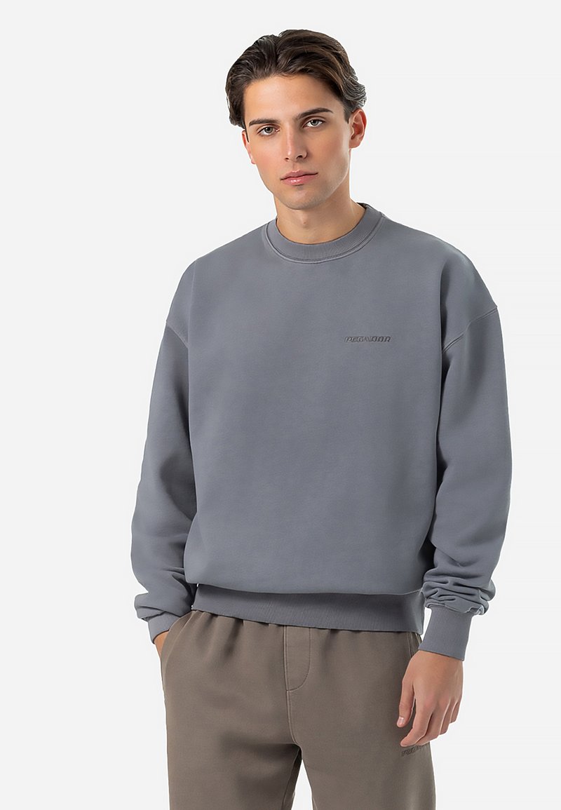Grå sweatshirt med rund halsudskæring, ribstrikkede manchetter og kant. Har et diskret præget logo foran. Stoffet ser blødt og glat ud.