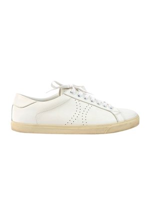 Biały niski skórzany sneaker z beżową podeszwą, sznurowany z przodu i perforowanym wzorem z boku, pokazany z prawego profilu.