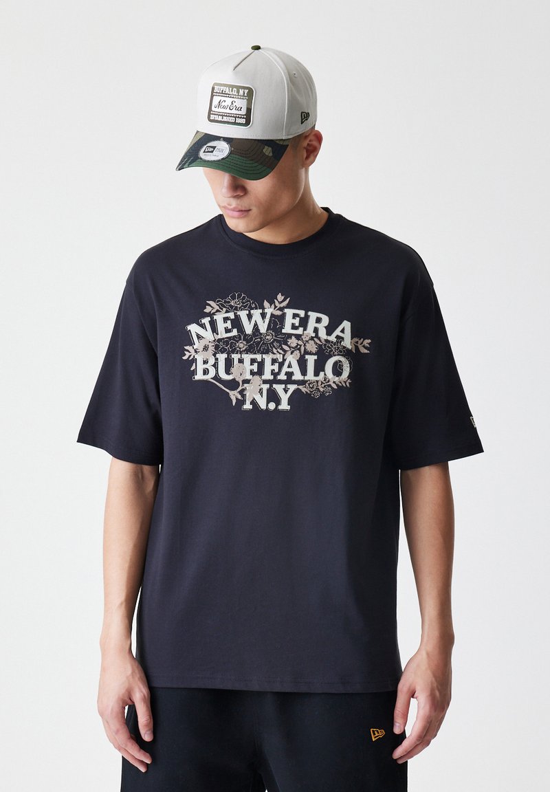 Črna bombažna majica s kratkimi rokavi, ki prikazuje grafiko "NEW ERA BUFFALO N.Y." v svetlo srebrni barvi, z ohlapnim krojem.