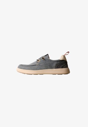 Baskets décontractées à enfiler en tissu gris avec semelle beige, détail noir au talon et languette rouge à l’arrière.