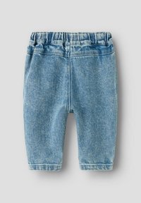 Svijetloplave dječje traperice s elastičnom gumom u struku, prednjim šavom i lagano sužavajućim nogavicama na neutralnoj sivoj pozadini.