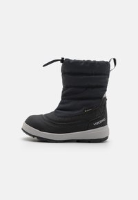 Botte d'hiver noire avec un dessus en nylon matelassé, semelle en caoutchouc, fermeture à cordon et marquage "GORE-TEX" sur le côté.