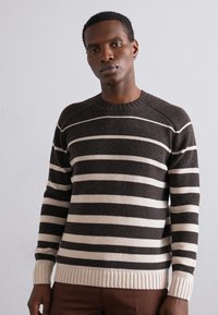 Pulover tricotat în dungi marron și crem, cu guler rotund, manșete și tiv cu nervuri. Prezintă un finisaj texturat și mâneci raglan.
