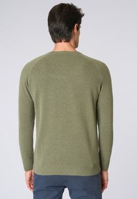 Maglione a maglia verde oliva con maniche lunghe, collo rotondo e orlo a costine. Texture morbida, design semplice, senza motivi o accenti visibili.