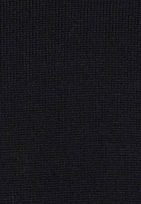 Tessuto nero con una superficie texturizzata a righe, maglia fine, superficie uniforme, adatto per vari utilizzi tra cui abbigliamento o tappezzeria.