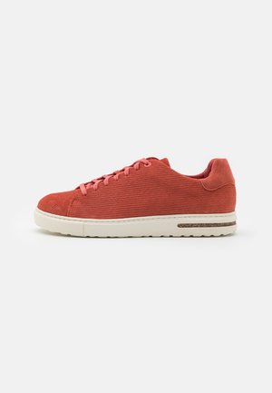 Røde corduroysneakers med rund tå, rosa lisser og en hvit gummisåle med korkdetalj og teksturert overflate.