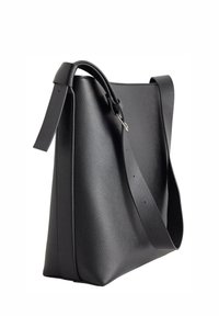 Sac en cuir noir avec une surface texturée, une bandoulière réglable et une forme structurée présentant des lignes épurées et minimalistes sans hardware visible.