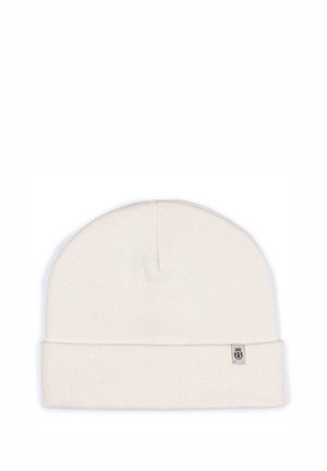 Cream-colored knit beanie with a folded cuff, made of soft material, featuring a small branded label on the side. Simple and seamless design.