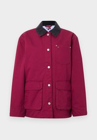 Bordowa kurtka z czarnym kołnierzem z sztruksu, zatrzaskami, dwoma przednimi kieszeniami i małą kieszonką na piersi. Materiał bawełniany o fakturze.
