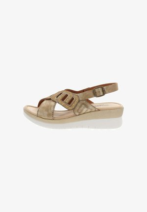 Sandalia beige de punta abierta con tira ajustable en el tobillo, suela acolchada, patrones geométricos recortados y tacón de cuña blanco.