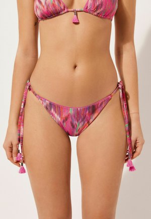 Bikini-Set mit einem pinken, mehrfarbigen Binden-Slip, das mit Quasten verziert ist. Das Material wirkt glatt und hat ein lebhaftes, abstraktes Muster mit glänzenden Akzenten.