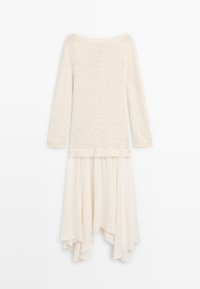 Crèmekleurige jurk met een lange gebreide trui en een vloeiende asymmetrische chiffon rok, weergegeven op een witte achtergrond.