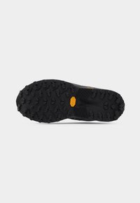 Μαύρη εξωτερική σόλα από καουτσούκ Vibram με επιθετικό σχέδιο πέλματος, σχεδιασμένη για βελτιωμένη πρόσφυση σε εξωτερικό έδαφος.