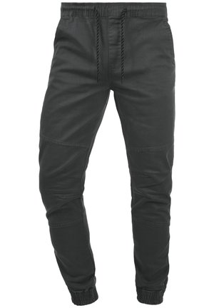 Schwarze lässige Jogginghosen mit elastischem Bund, Zugband, Naht an den Knien und elastischen Bündchen an den Knöcheln.