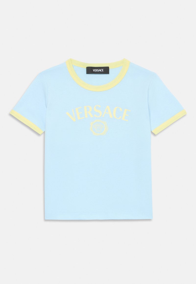 T-shirt de algodão azul claro com mangas curtas. Gola e punhos em amarelo canelado. Apresenta o logótipo "VERSACE" centrado e um gráfico abaixo.