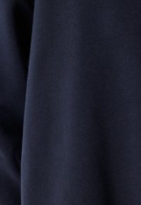 Tela de algodón azul marino, con textura suave y superficie uniforme con un ligero estiramiento. No presenta patrones ni costuras visibles.