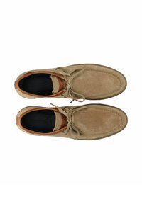 Vaaleanruskeat nupukkinahkaiset nauhalliset kengät, joissa on sileä nahkainen korostus kantapäässä ja tumma sisäpohja. Kengissä on ompelut ja pyöreä kärki.