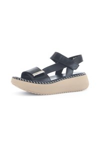 Zwarte leren sandalen met een plateauzool, voorzien van een dikke beige basis, kruisbanden en een zilveren accent aan de voorkant.