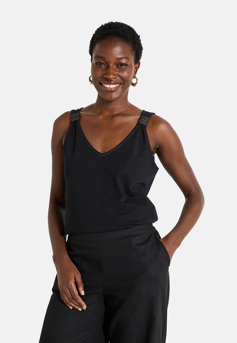 Top negro sin mangas con escote en V, con tirantes texturizados y detalles metálicos. Tela suave, corte relajado, combinado con pantalones oscuros.