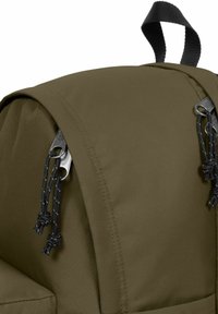 Olijfgroene rugzak met een gestructureerde stof, een afgeronde bovenkant en dubbele metalen accenten met zwarte trekkoorden en knopen.