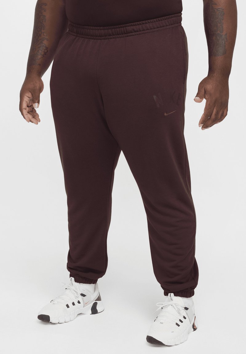 Mörkröda Nike sweatpants med elastisk midja, sidofickor och tapered muddar. Diskret ton-i-ton logotypdetalj på vänster ben.