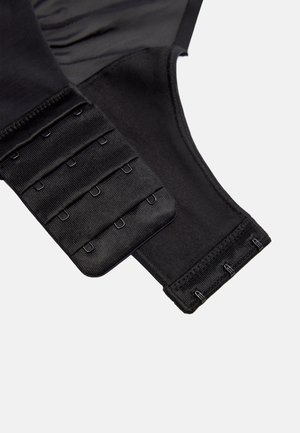 Sección de cierre de sujetador de tela negra con tres filas de ganchos en un lado y cuatro filas de ojales en el otro para un ajuste ajustable.