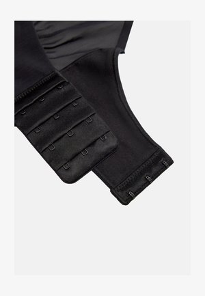 Sección de cierre de sujetador de tela negra con tres filas de ganchos en un lado y cuatro filas de ojales en el otro para un ajuste ajustable.