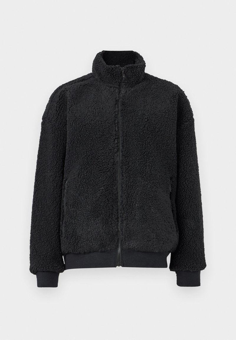 Sort fleecejakke med høj krave, lynlås og ribstrikkede manchetter. Teksturen er blød og luftig med en afslappet pasform.