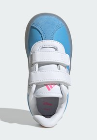 Chaussure de sport bleue et blanche avec des bandes velcro, en matériau suédé et synthétique, à bout arrondi, logo en relief et intérieur texturé.