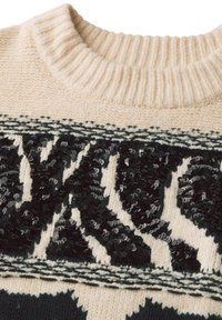 Maglione a maglia crema con scollatura a costine, caratterizzato da stampa animale in paillettes nere e motivi geometrici, texture morbida e bordo a contrasto.