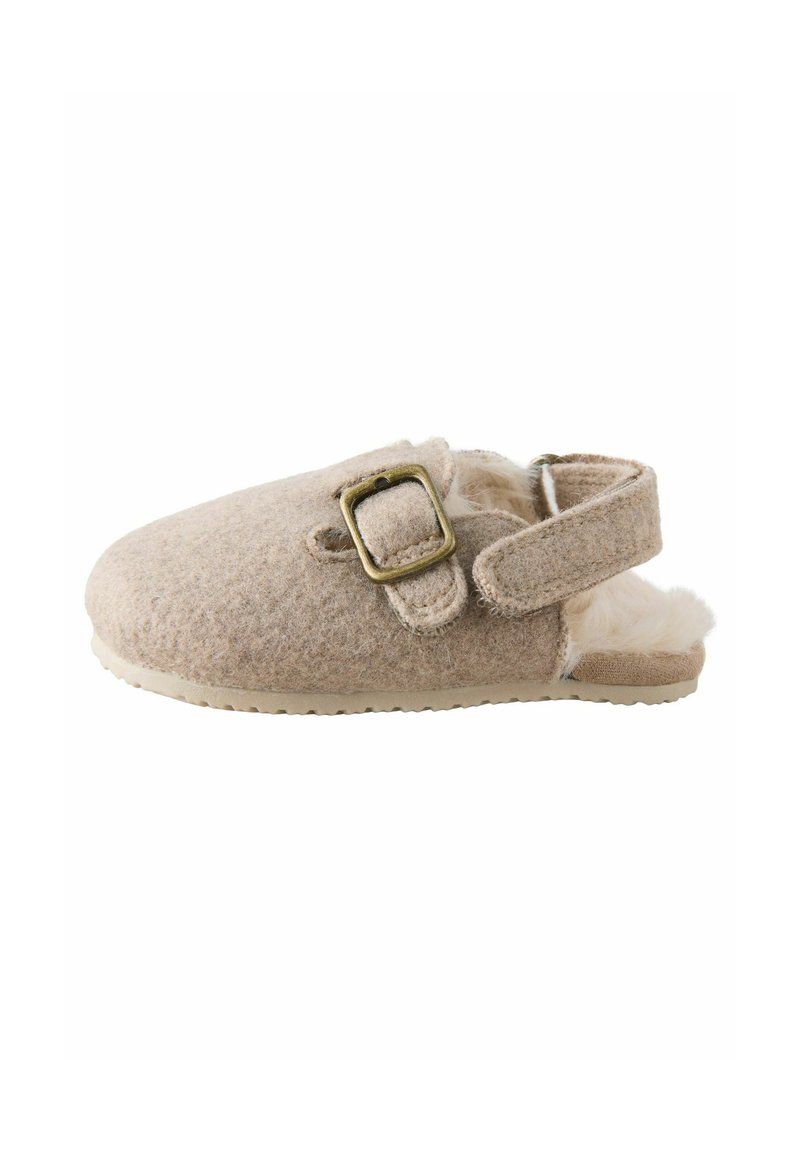 Chausson en feutre beige avec fermeture à bouclerie, à dos ouvert, doublé en peluche et semelle en caoutchouc. Texture douce et forme arrondie.