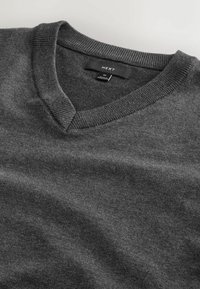 Pull gris foncé col V avec col côtelé, taille moyenne, étiqueté "NEXT" et fabriqué au Bangladesh.