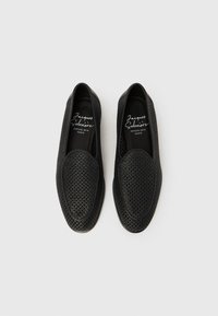 Μαύρα παπούτσια χωρίς κορδόνια με περίγραμμα και στρογγυλεμένη μύτη. Ομαλή υφή, ευέλικτο υλικό. Το εσωτερικό διαθέτει λογότυπο σε λευκό χρώμα.