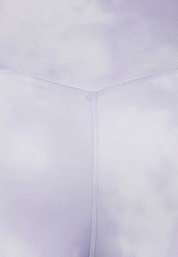 Fioletowe legginsy z efektem tie-dye, wykonane z gładkiej, elastycznej tkaniny, z płaskimi szwami i dopasowanym krojem. Brak widocznych elementów metalowych lub ozdobnych akcentów.