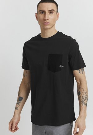 Black cotton t-shirt with short sleeves, a round neck, and a left chest pocket. Features a small logo tag on the pocket.