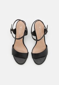 Black heeled sandals with a smooth leather upper, wide front strap, and an adjustable ankle strap. Interior features a beige lining.