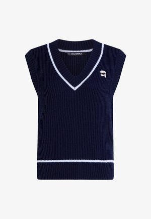 Tamsiai mėlynas nėriniuotas megztinis be rankovių su V formos iškirpte ir baltais dryžiais. Yra mažas logotipas išsiuvinėtas ant krūtinės.