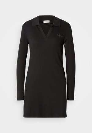 Robe polo noire à manches longues avec un décolleté en V, texture côtelée et un logo discret sur la poitrine gauche. Matériau en mélange de coton doux.