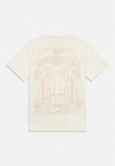 T-shirt couleur crème avec des colonnes baroques complexes et un design architectural beige pâle dans le dos.