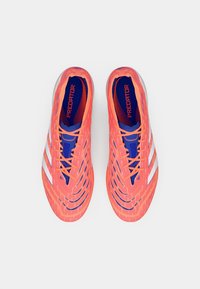 Botas de fútbol de color rosa brillante con una superficie texturizada, detalles en azul y rayas blancas. Diseñadas para la agilidad y la tracción en el campo.